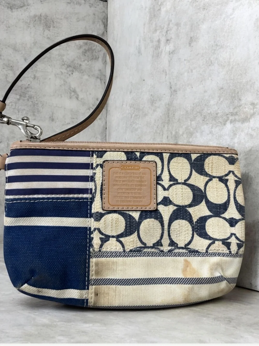 Coach wristlet featuring signature patchwork print in navy and cream